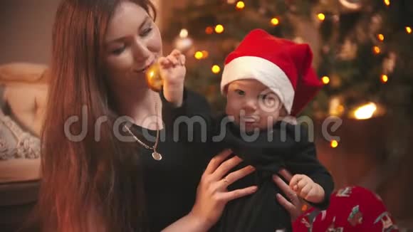 圣诞节概念一个微笑的女人和她的小儿子玩婴儿拿着圣诞球视频的预览图