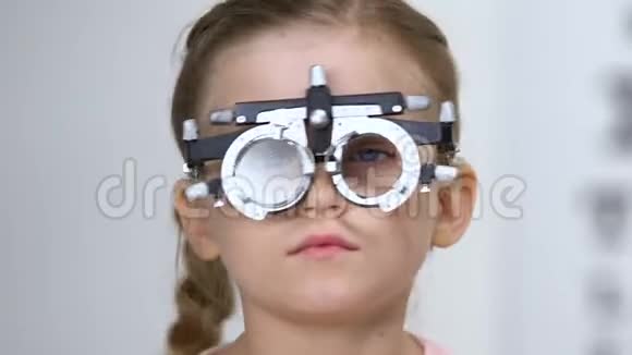男性眼科医生为戴光镜的小女孩选择眼镜视频的预览图