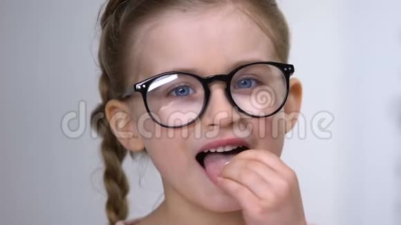 戴眼镜的小女孩服用白丸视力维生素健康补充剂视频的预览图