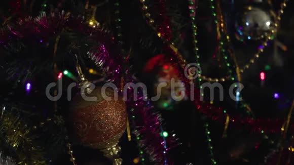 新年的背景是一棵装饰好的圣诞树上面有一个闪闪发光的花环闪烁着节日的五颜六色的火花视频的预览图