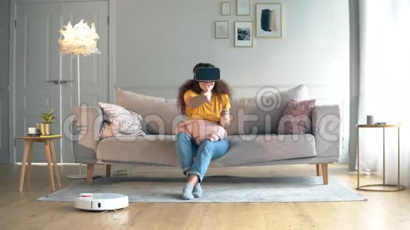 机器人胡佛正在和一个穿着VR眼镜的女孩一起打扫房间视频的预览图