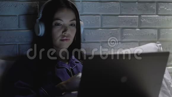 戴耳机的女士在笔记本电脑上看电影音量有问题视频的预览图