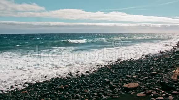 海上冲浪海洋海岸波浪在绿松石水和白色泡沫上水滴飞入镜头火山黑色的石头海岸视频的预览图