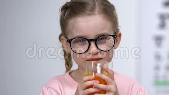 快乐的孩子在眼镜里喝胡萝卜汁特写强烈的视力维生素A视频的预览图