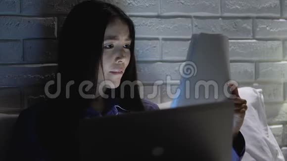 强迫女工检查文件晚上在床上使用笔记本电脑视频的预览图