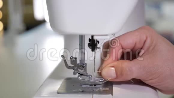 女人在缝纫机里扎针准备工作双手特写视频的预览图