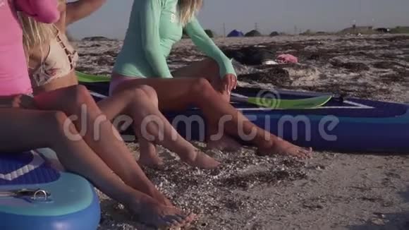 三个年轻女子坐在沙滩上看日落视频的预览图