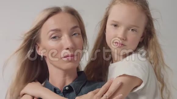 特写摄影棚的母亲和女儿拥抱她亲吻她视频的预览图