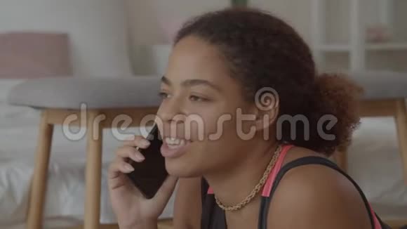 可爱的非裔美国女人用手机说话视频的预览图