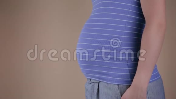 美丽的孕妇摸着肚子一只手放在背上视频的预览图