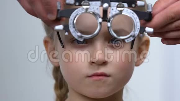 眼科医生帮助小女孩戴上眼罩视力检查诊断视频的预览图