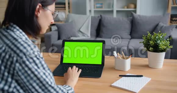 在家使用绿色模拟屏幕笔记本电脑的人的慢动作视频的预览图