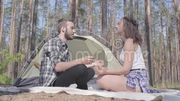 画像青年男女坐在林前沉思背景上的帐篷爱视频的预览图