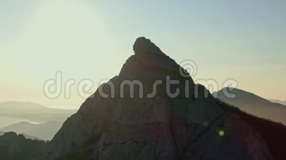 在山脉和海洋的背景下空气围绕着山顶飞行视频的预览图