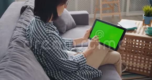 慢动作女孩使用平板电脑与绿色模拟屏幕触摸显示视频的预览图