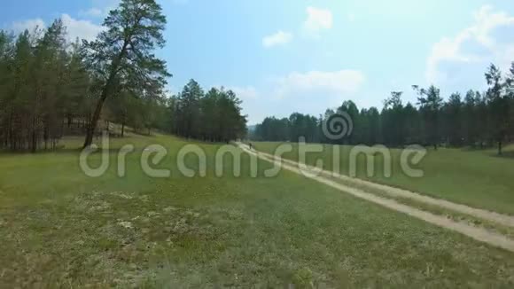 无人驾驶飞机沿着乡间小路飞行经过行走的女孩然后站起来视频的预览图