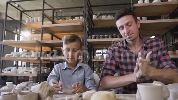 可爱的白种人男人和他可爱的儿子在陶器上玩得很开心视频的预览图