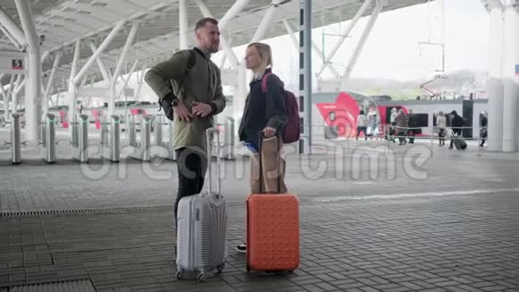 出发前两位旅行者站在站台上手提行李视频的预览图