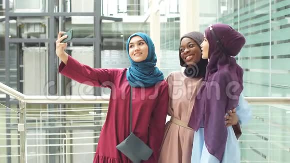四组穆斯林妇女戴着传统头巾在商场自拍视频的预览图