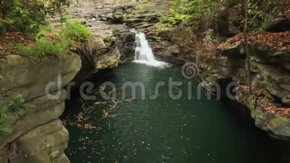 瀑布倒在水池里秋天的树叶飘落下来视频的预览图