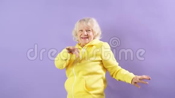 微笑成熟的模特在紫色背景上跳舞心情好派对快乐视频的预览图