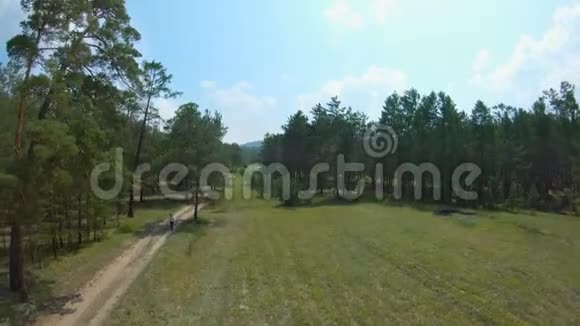 无人机飞了起来拍摄了走在乡间小路上的女孩视频的预览图