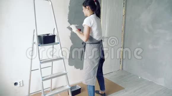 女工人用抹刀在公寓或房子里涂上装饰石膏建筑修理和翻新视频的预览图