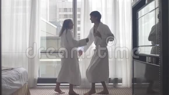 到达酒店后年轻迷人的情侣穿着浴袍跳舞视频的预览图
