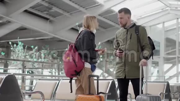 男女旅客正在机场大厅里手提行李箱视频的预览图