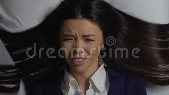 哭泣的亚洲女经理躺在文件下过度工作的问题视频的预览图