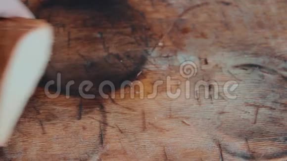 男手用钢刀在木制厨房砧板上切一条白面包人们早餐供应面包视图f视频的预览图
