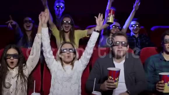 一群快乐的朋友在电影院里戴着眼镜看3D电影视频的预览图