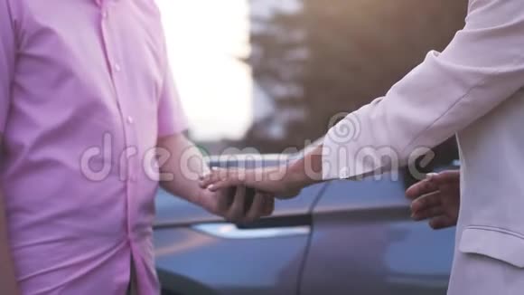 商人在一辆车的背景上收到车钥匙交易成功商业人士握手关门视频的预览图