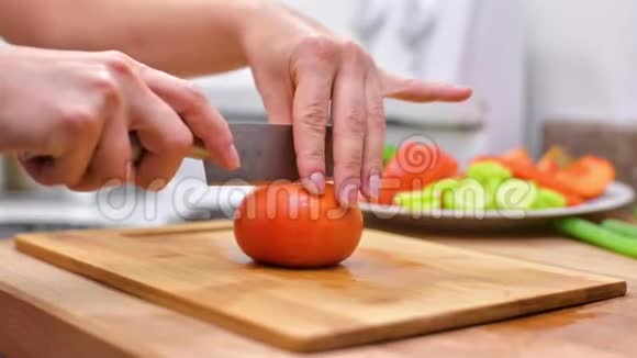 女人用菜刀在木板上切鲜柿子视频的预览图