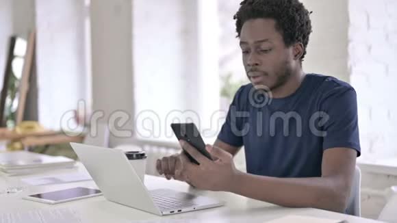 专注于使用智能手机和笔记本电脑的非洲男人视频的预览图
