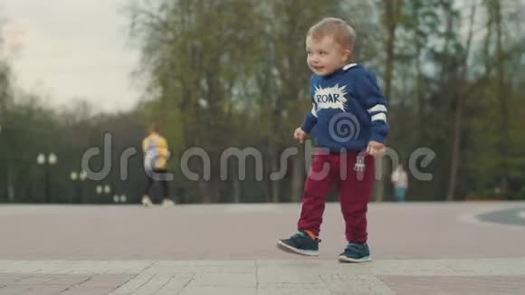 小男孩滑稽地跑在公园里第一个小朋友步骤视频的预览图