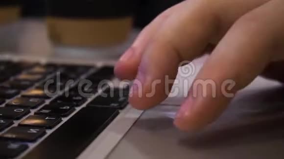 当男人用手在笔记本电脑上打字并使用触摸板时特写镜头视频的预览图