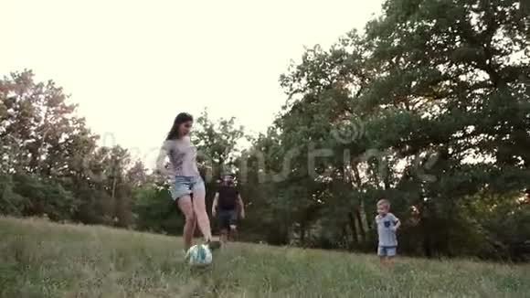 一个孩子和父母和家人朋友在森林空地上玩球视频的预览图