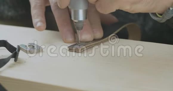 一个皮革工艺品手工钻洞在皮革支架上与一个钻手工制品电影院4k视频C4k视频的预览图