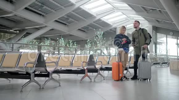 已婚夫妇带着手提箱白天在车站的候车厅里视频的预览图