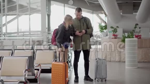 几个游客正走过机场大厅提着手提箱视频的预览图