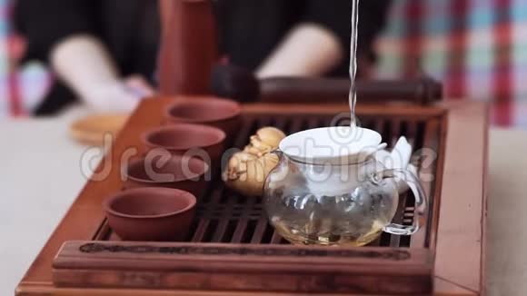 通过水壶里的筛子倒入美味的茶然后倒入杯子里茶道仪式视频的预览图