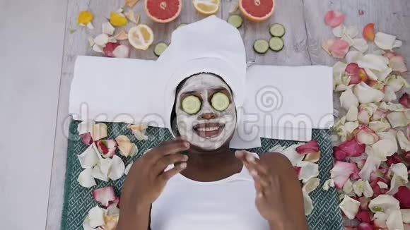 美丽的非洲年轻女子头上戴着白色毛巾脸上挂着黄瓜视频的预览图