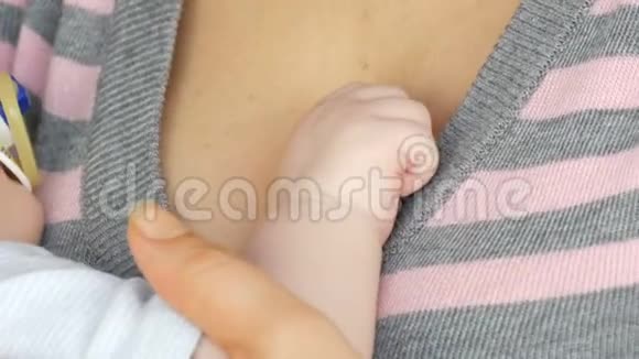 两个月刚出生的婴儿的小手放在母亲的胸前视频的预览图