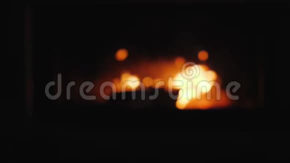 在壁炉的背景下用酒杯夹着葡萄酒那里的火在燃烧视频的预览图