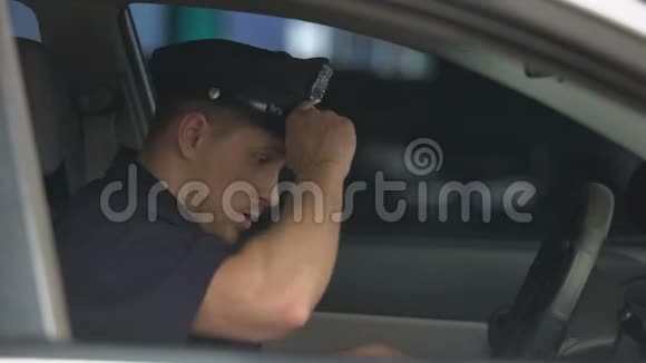在紧张的事故和辛苦的工作之后精疲力竭的警察上了车视频的预览图