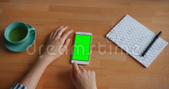 慢动作的人手触摸绿色智能手机屏幕与小工具视频的预览图