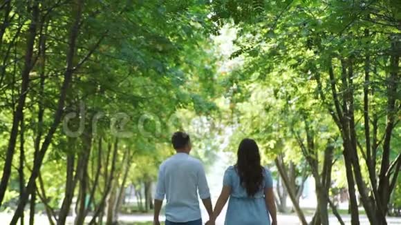 男人和他怀孕的妻子在城市公园散步视频的预览图