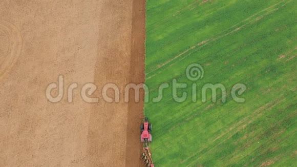 拖拉机耕植农作物气顶前的绿色农田视频的预览图