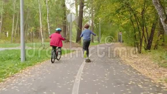 公园儿童骑自行车和滑板的后景视频的预览图